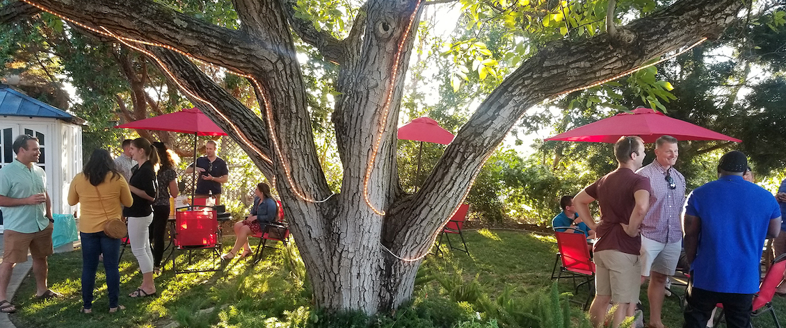 People standing around a lit tree in the Winery's tasting area